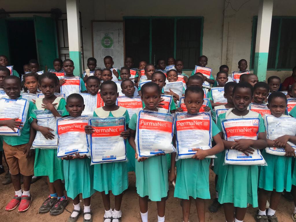School children in Atebubu ATSEC Model Primary School holding their ITNs after receiving them through school-based distribution.